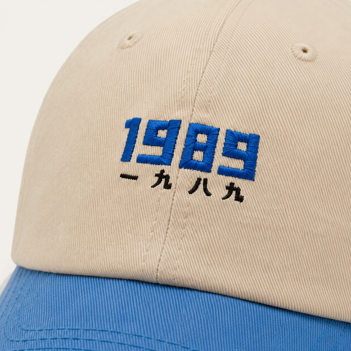 The Rue '89 Contrast Cap in Cream / Royal, fabric and hardware detail.