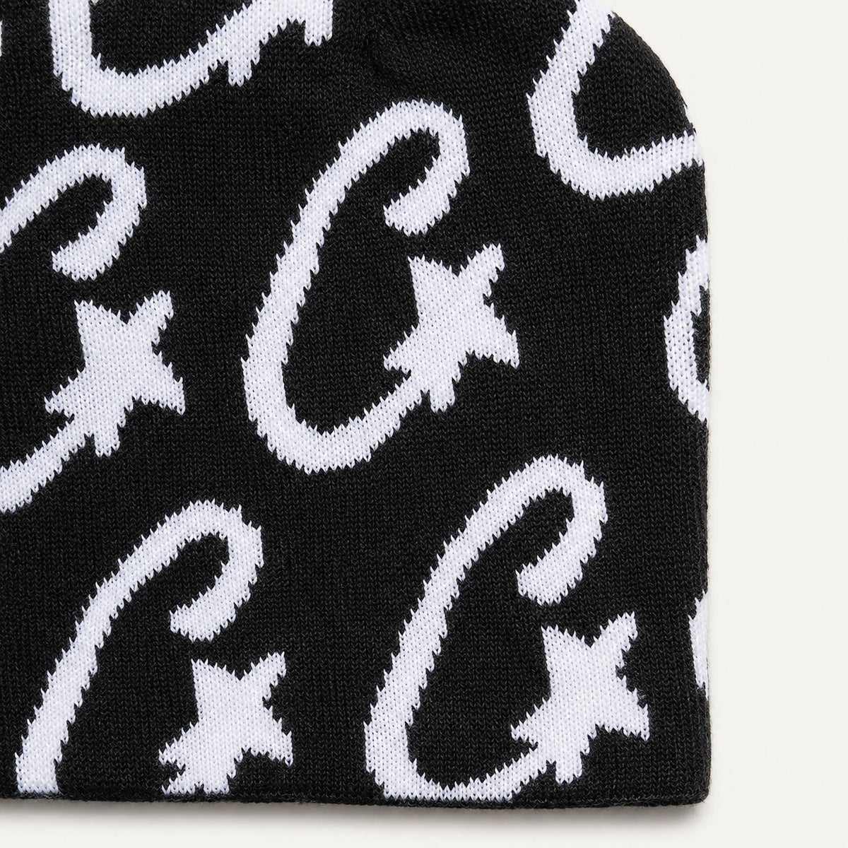 The Rue Signal Jacquard Beanie in Black, fabric and hardware detail.
