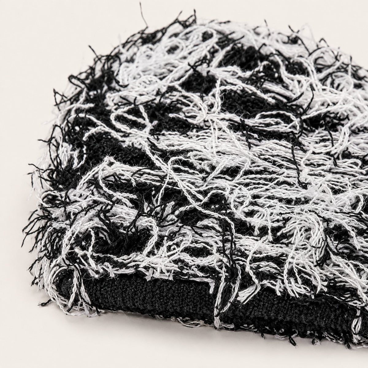 The Tangled Knit Beanie in Black And White, fabric and hardware detail.