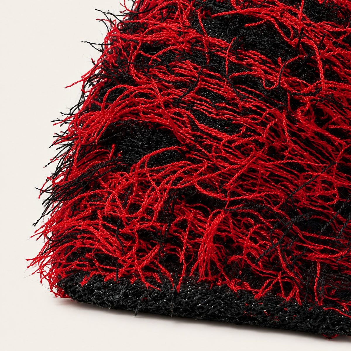 The Tangled Knit Beanie in Black And Red, fabric and hardware detail.